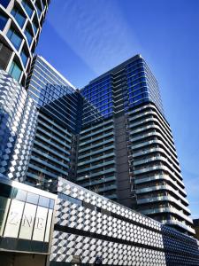 a tall building with blue glass windows on it at Sky tower space in Katowice +7 photos