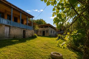 an old house with a yard in front of it at Sarag Family Guesthouse Svaneti in Mestia