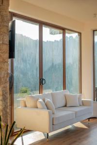 a white couch in a living room with windows at Beverly Hills Retreat in Kandilpana