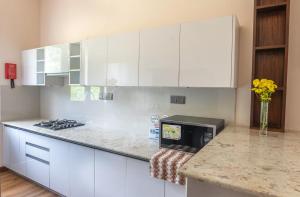 a kitchen with white cabinets and a counter top at Beverly Hills Retreat in Kandilpana