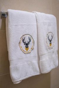 two white towels with a picture of a deer on them at Beverly Hills Retreat in Kandilpana +86 photos