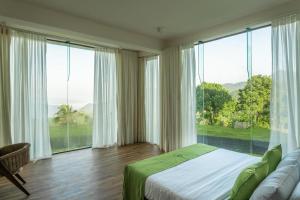 a bedroom with a bed and a large window at Beverly Hills Retreat in Kandilpana