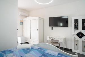 a bedroom with a bed and a tv on the wall at Santa Maria Rooms in Santa Maria di Castellabate