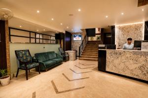 a man standing at a counter in a hotel lobby at Click Sunburry Hotel Katra in Katra