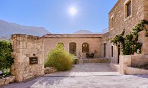 a stone house with a courtyard in front of it at Villa Iremia in Nísi