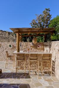 a wooden table and chairs on a stone patio at Villa Iremia in Nísi