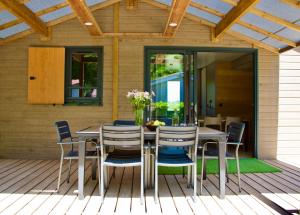 a dining room table and chairs on a deck at Le Domaine du Cèdre in Rivières