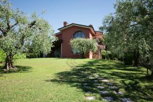 a red house with trees in front of it at Casa Terra Holiday in Padenghe sul Garda
