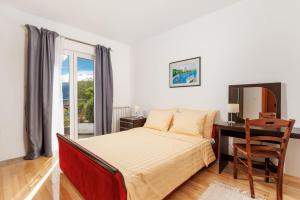 a bedroom with a bed and a desk and a window at Apartments Bellavista in Matulji +83 photos