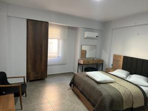 a bedroom with a bed and a desk and a chair at kuyulu konak in Uşak