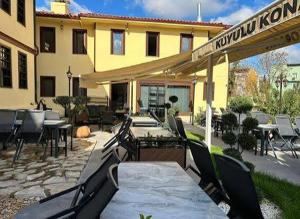 a patio with a table and chairs in front of a building at kuyulu konak in Uşak