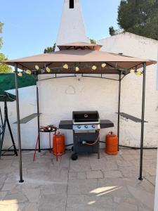 a barbecue grill under a pavilion with a roof at Amarella Costa Dorada - Alojamientos privados en villa mediterránea con amplia piscina y zonas BBQ in Les tres Cales +89 photos