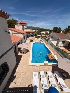 a pool with chaise lounge chairs and a person in a swimming pool at Amarella Costa Dorada - Alojamientos privados en villa mediterránea con amplia piscina y zonas BBQ in Les tres Cales
