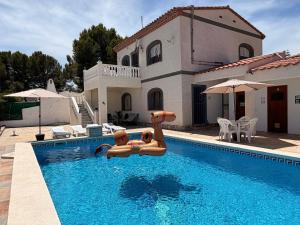 a swimming pool with two inflatables in front of a house at Amarella Costa Dorada - Alojamientos privados en villa mediterránea con amplia piscina y zonas BBQ in Les tres Cales