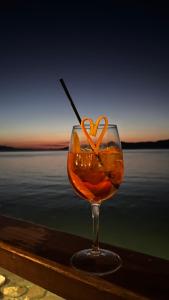 a wine glass with an orange heart in front of the water at ARTEMIS ROOMS in Pefki