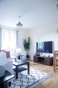 a living room with a couch and a tv at Luxury 2 Bedroom serviced accommodation in Solihull