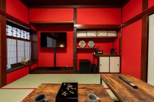 a room with red walls and a wooden table at 金沢町家 凛 in Kanazawa