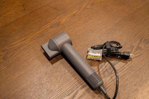 a blow dryer on a wooden floor with a charger at 金沢町家 凛 in Kanazawa