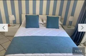 a bed with two blue pillows in a bedroom at Casa Annacarla in Noci +8 photos