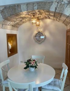 a dining room with a white table and chairs at Casa Annacarla in Noci