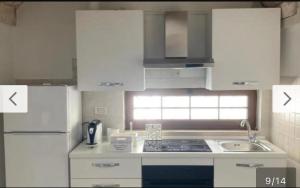 a white kitchen with white cabinets and a sink at Casa Annacarla in Noci