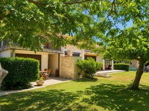 a house with a yard with a tree at Apartment House with Shared Pool in Premantura