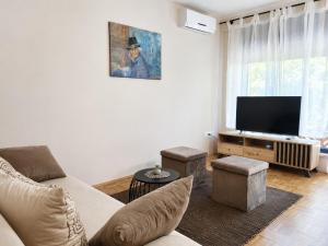 a living room with a couch and a flat screen tv at Apartment House with Shared Pool in Premantura