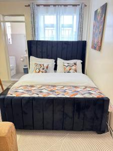 a large bed with a blue headboard in a bedroom at Sunrise Hills BNB in Ngong