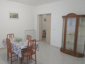 a dining room with a table and chairs and a cabinet at Casa Amica Termoli 1 in Termoli +2 photos