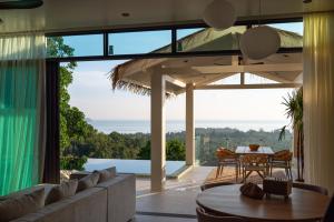 a living room with a couch and a table at Siam Mila Villas in Srithanu