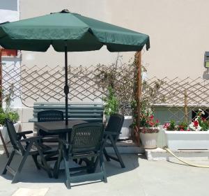 a table and chairs with a green umbrella at Casa Amica Termoli 1 in Termoli