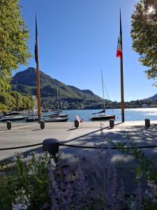a person sitting on a sidewalk next to a body of water at Eva Urban Rooms Centro Lecco in Lecco