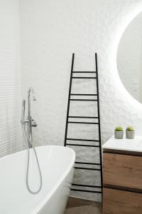 a bathroom with a white bath tub and a ladder at Le Lamartine - Vue Saône - Hypercentre in Mâcon +13 photos