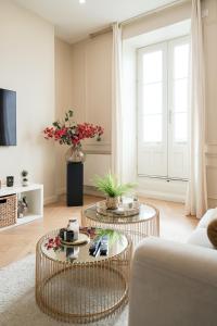 a living room with two tables and a couch at Le Lamartine - Vue Saône - Hypercentre in Mâcon