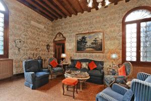 Una sala de estar con un sofá y sillas y una mesa. en Cà Martinengo, en Venecia