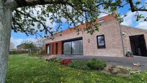 a brick house with a large window in a yard at Gîte La Siroperie in Wanze +8 photos