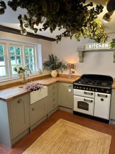 a kitchen with a stove and a sink at Spring Cottage in Hoylake
