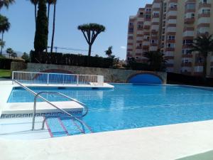 a large swimming pool in a building with palm trees at Estudio 86 B in Torrox Costa +5 photos