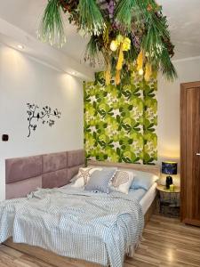 a bedroom with a large bed with a green wall at Pokoje Gościnne in Kołobrzeg