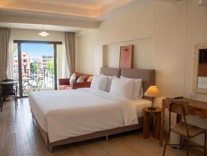 a bedroom with a large white bed and a desk at An190 Boutique Hotel in Bangkok