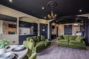 a living room with two green couches and a table at The Clyffe Hotel in Lowestoft