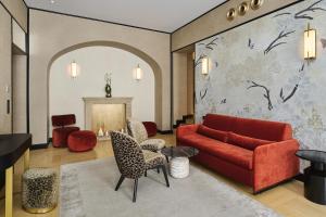 a living room with a red couch and chairs at Hotel Experior Boutique - Destigo Hotels in Krakow
