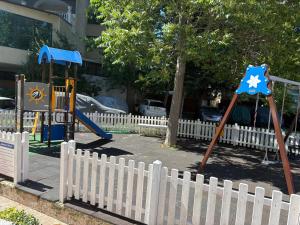 a playground with a white fence and a swing set at ADMIRAL PLASA studiyo-25C in Sunny Beach