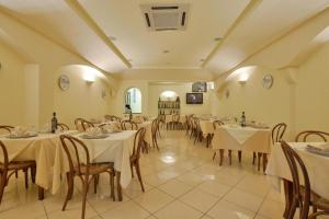 a restaurant with tables and chairs with white table cloth at Santa Maria Rooms in Santa Maria di Castellabate