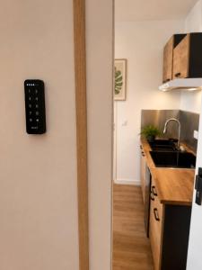 a kitchen with a remote control on the wall at Voyageur - Vidéoprojecteur - Terrasse - 5min gare in Ploumagoar