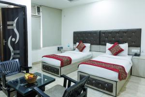 a hotel room with two beds and a table at Hotel Ornate Residency And Suites in Gurgaon