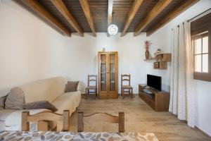 a living room with a couch and a tv at Casa El Duque Zaira in Vejer de la Frontera