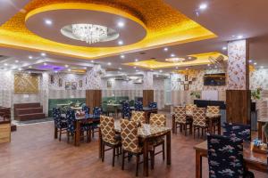 a restaurant with tables and chairs in a room at Hotel Ornate Residency And Suites in Gurgaon
