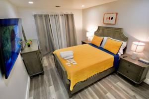 a bedroom with a large bed with a yellow blanket at The Modern Suite - 2BR Close to NYC in Paterson