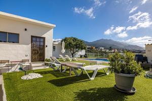a backyard with a table and chairs on the grass at vv Mirador Al Mar in El Paso